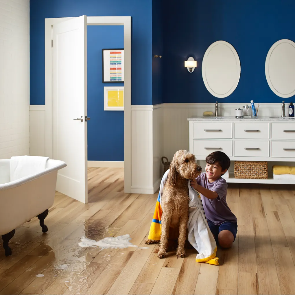 Child Bathing a Dog in Bathroom with Luxury Vinyl Flooring | Haight Carpet & Interiors