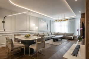 dark hardwood flooring in contemporary living and dining room with modern lighting neutral furniture and area rug